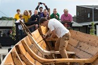 Ein Mann arbeitet an einem Holz-Wikingerschiff im Wikingerschiffsmuseum in Roskilde